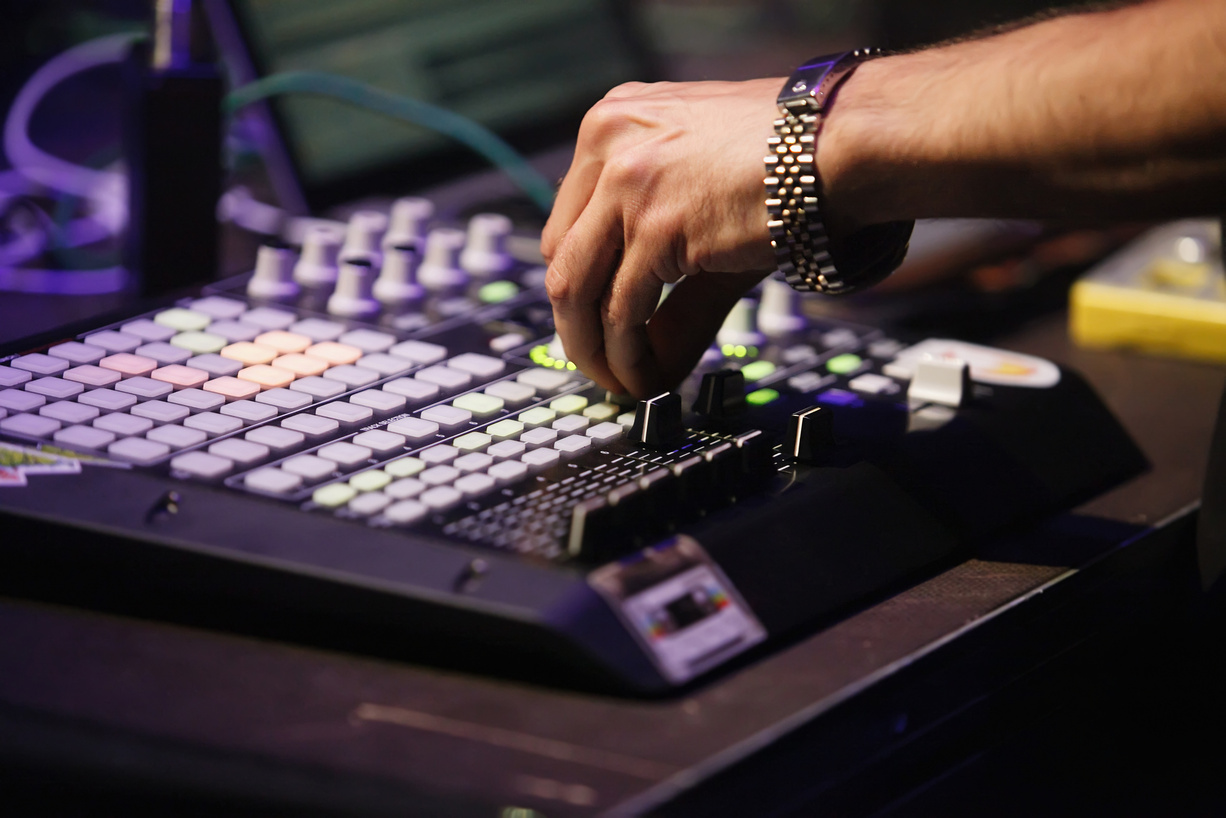 Beat maker plays hip hop music on concert. Music producer playing beats with modern drum machine device